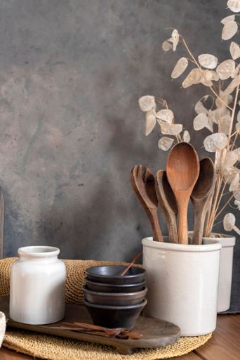 A vertical closeup of kitchen utensils on the wooden table.
