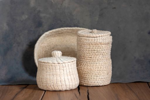 A closeup of small jute baskets with lids.