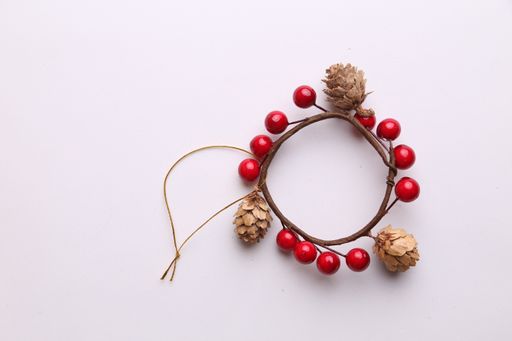 An ornament used for hanging on Christmas trees made of acorns and cherries