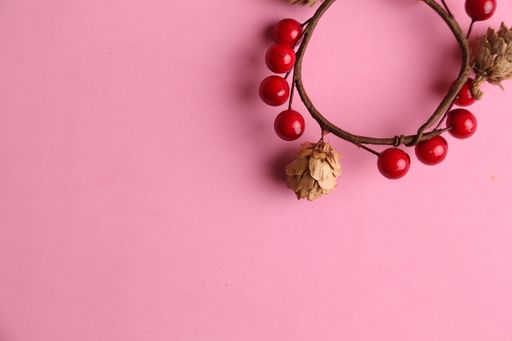 A closeup shot of a decorative wooden trinket isolated on a pink background
