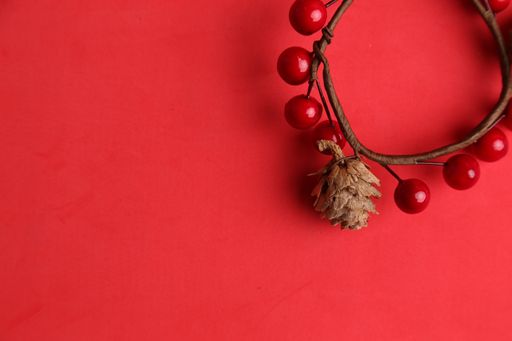 An overhead shot of a decorative wooden trinket on a red background