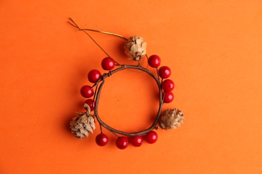 A high angle shot of a beautiful wooden trinket with red decorations
