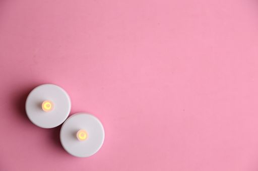 A top view of two plastic LED candles on a pink surface