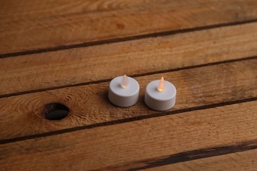 A closeup shot of white plastic led candles on a wooden table