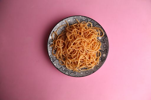 An overhead shot of a carrot salad in a plate with beautiful paintings on it