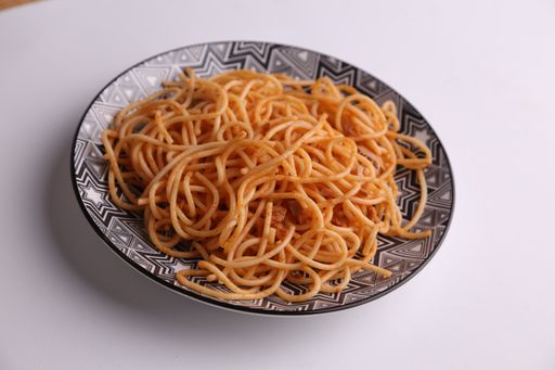 A close up shot of a bowl of cooked spaghetti isolated on a white background