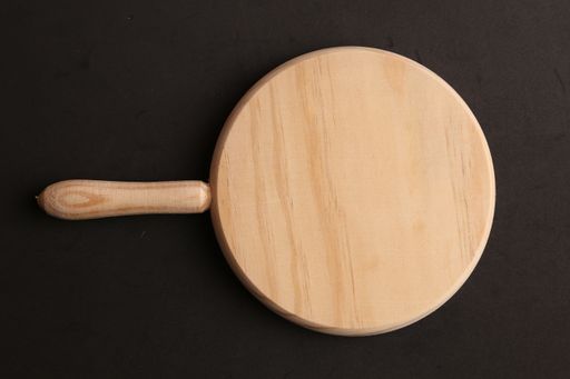 A high angle shot of a wooden cutting board isolated on a black surface