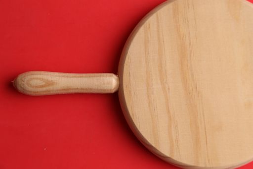 A top view of round wooden board on red background