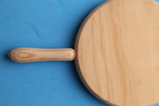 A high angle shot of a wooden cutting board isolated on a blue surface