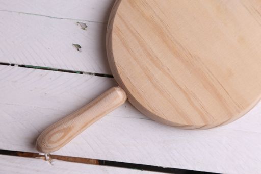 The new wooden cutting board on the wooden surface