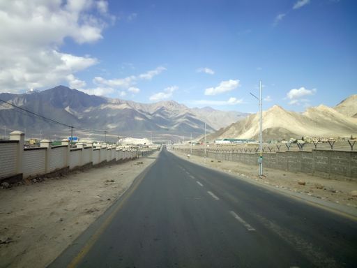 A road at the foot of a bare mountain in Ladakh, India
