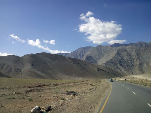 A road at the foot of a bare mountain in Ladakh, India