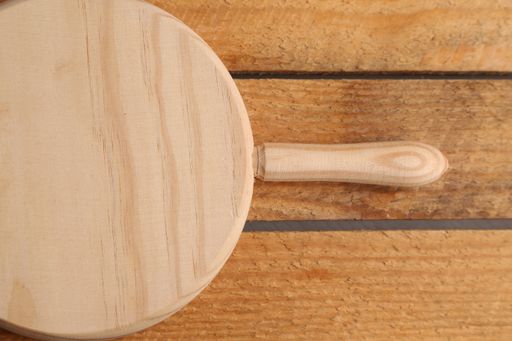 A closeup shot of a wooden chopping board on a wooden surface