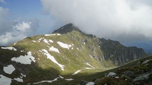 A beautiful view of high mountain landscape with green valley under cloudy sky on sunny day