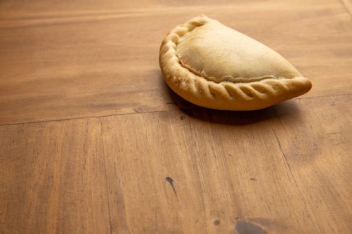 A high angle shot of delicious fried calzone isolated on a wooden surface