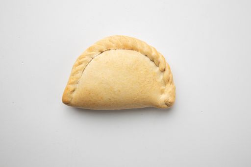 A top view of baked empanada on white background