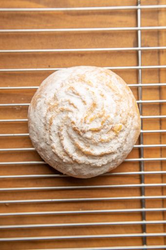 A vertical shot of a vanilla cookie isolated  on a brown background