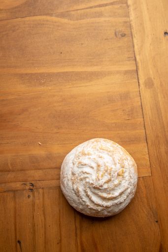 A vertical high angle shot of a homemade cookie isolated on a wooden surface