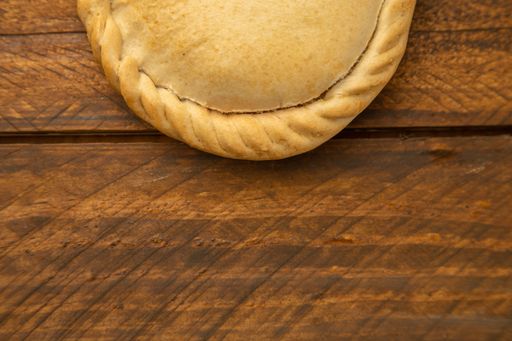 A top view of an Empanada on a wooden table under the lights