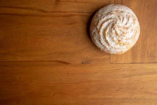 A top view of a powdered round pastry on a wooden table