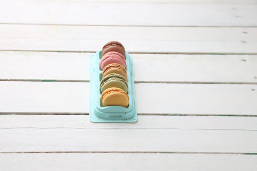 A bunch of colorful macarons arranged vertically on a tray