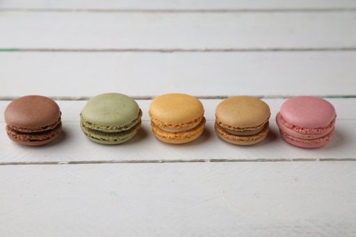 A closeup of different macarons on a wooden table - perfect for food concepts