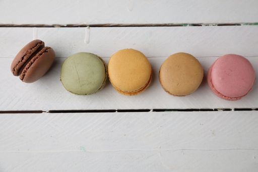 A top view of colorful macarons on white background