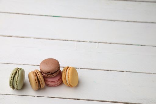 A closeup shot of delicious sweet macarons on a wooden surface