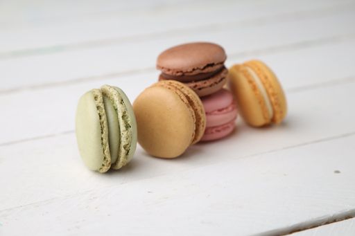 A closeup shot of colorful macarons on a white wooden surface
