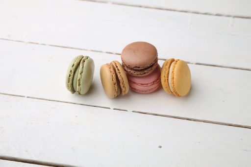 A closeup shot of colorful delicious macarons on a white kitchen table