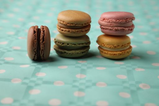 A selective focus shot of colorful macarons on a blue patterned surface