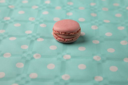 A closeup shot of a delicious macaroon on a green surface