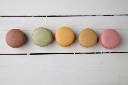 A top view of colorful macarons on white background