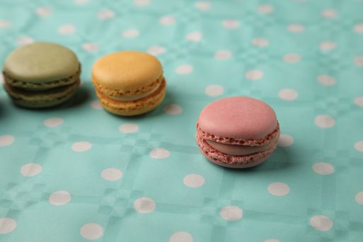 A closeup of a bunch of colorful macarons on a dotted surface