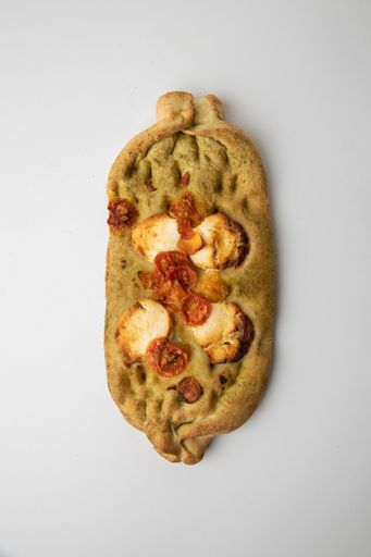 A vertical top view of a toast with tomatoes and cheese