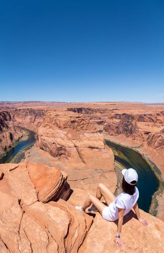 A young girl with white clothes at Horseshoe Bend in Page, Arizona on a sunny day