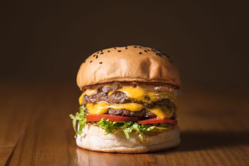 An appetizing double cheeseburger all ready and set on a wooden table