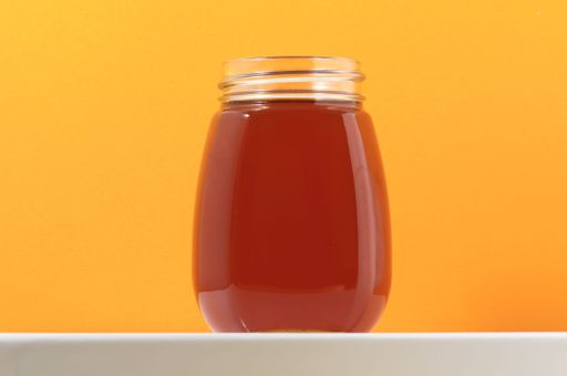One Full Honey Jar on a Colored Background