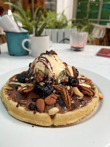 A vanilla ice-cream, walnut, almond, pumpkinseed, peanut, blueberry and Nutella waffle