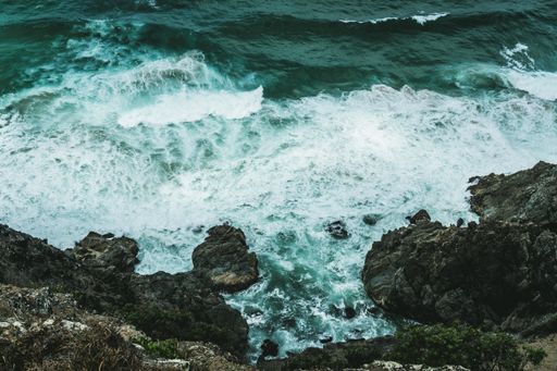 The waves hitting the rocks at the shore of the ocean