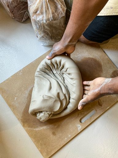 A man wedging clay using the Spiral Wedging technique