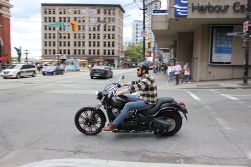 A Man riding a motorcycle in downtown Vancouver, British Columbia, Canada