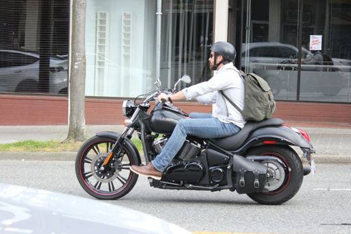 A Man riding a motorcycle in downtown Vancouver, British Columbia, Canada
