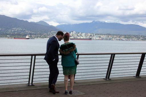 Young couple looking at a smartphone at the waterfront in downtown Vancouver, British Columbia, Canada