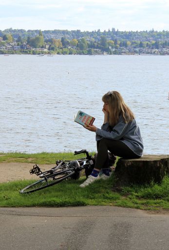 Pretty woman reading a book in downtown Vancouver, British Columbia, Canada