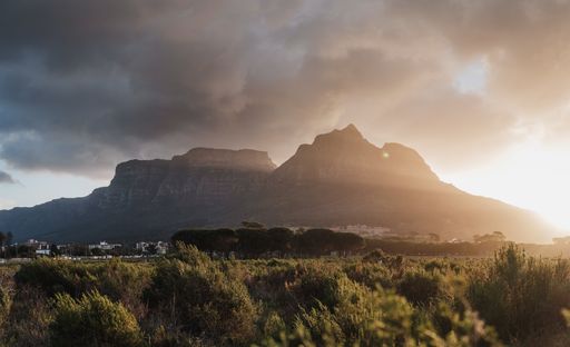 A breathtaking view of beautiful rock formations surrounded by green trees under the dark clouds