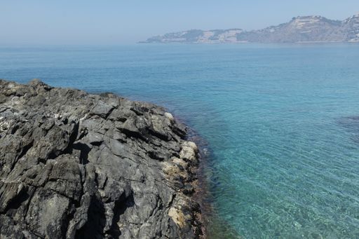 A breathtaking scenery of a seashore with big rocks under the clear blue sky in Spain, Almunecar, cliff San Cristobal