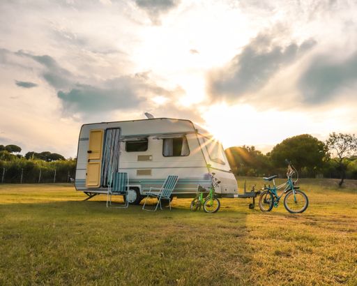 Two bicycles parked near a van in the field