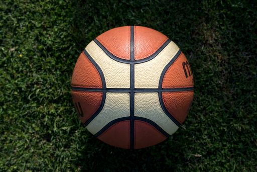 A top view of a basketball ball on the green lawn
