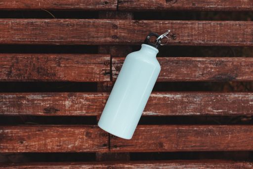 A top view of a metal bottle on a wooden table